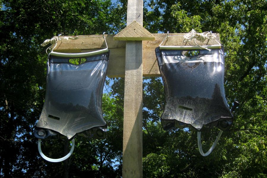 Two bags of solar showers hanged on stake
