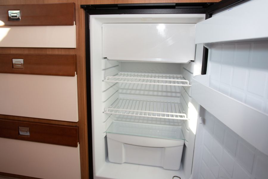 An empty RV mini fridge in camper van